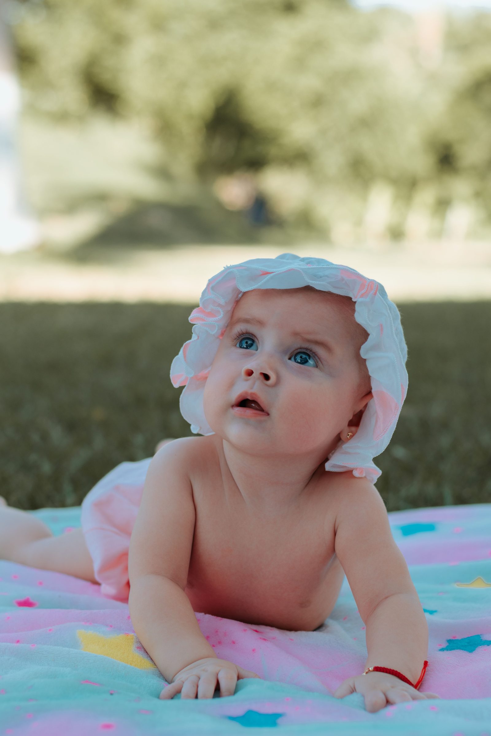 Un bebe porte un chapeau de soleil et se protege de la chaleur en exterieur