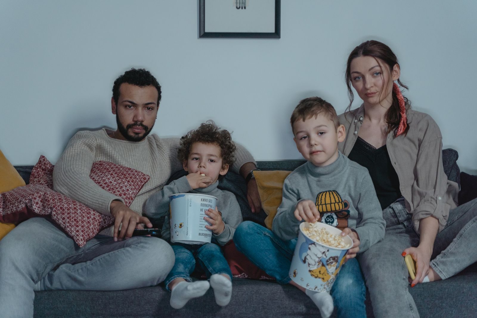 Une famille avec deux enfants regarde un film avec du pop-corn