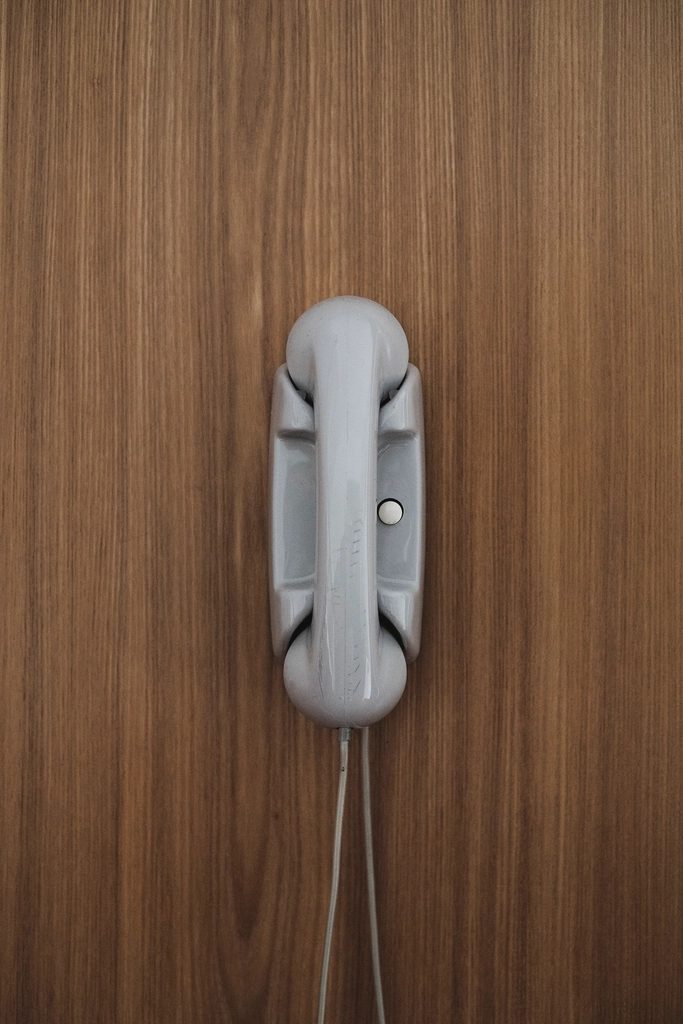 Téléphone fixe posé sur un mur en bois