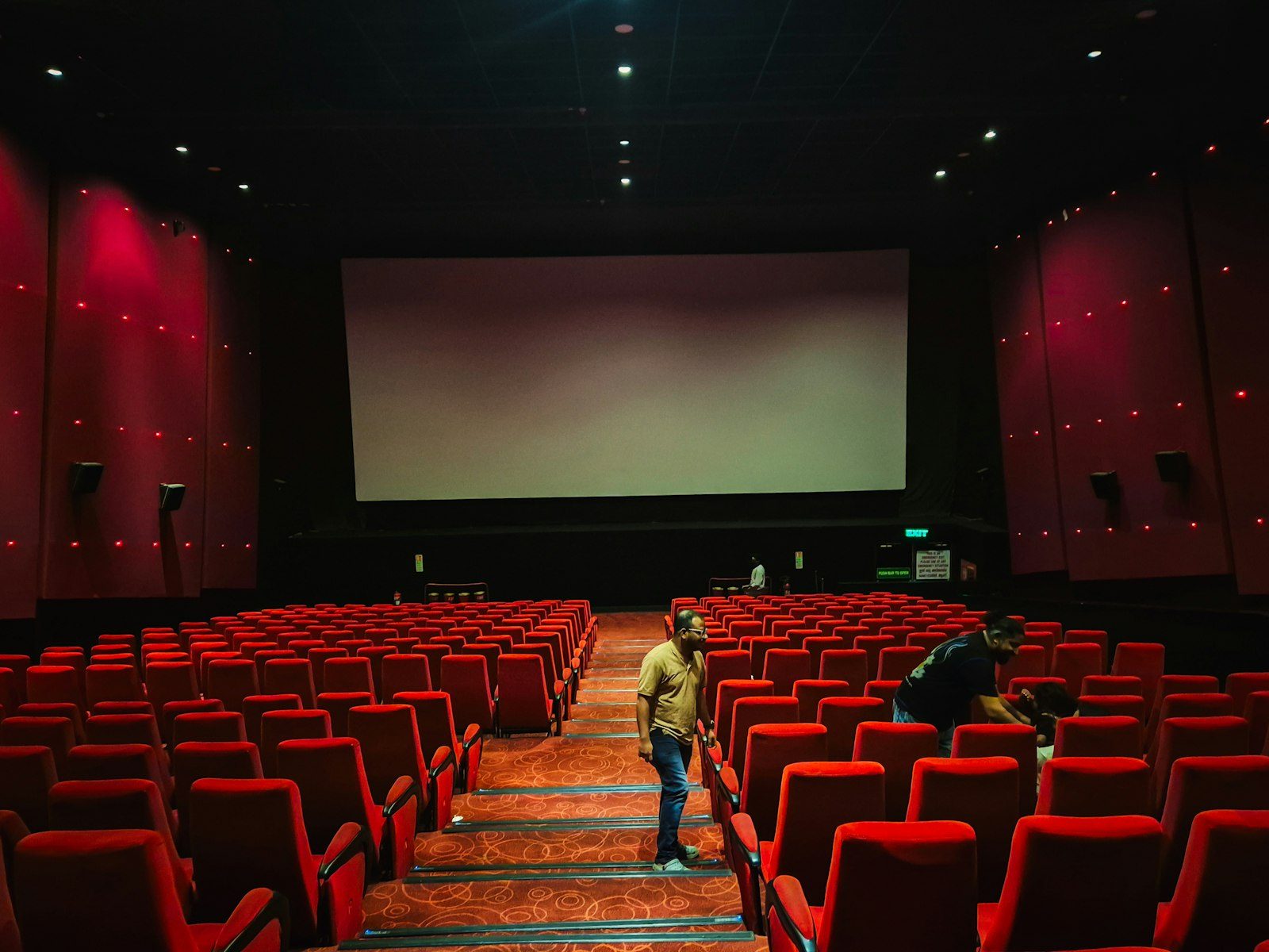 Salle de cinema avec sieges rouges avant une seance en famille