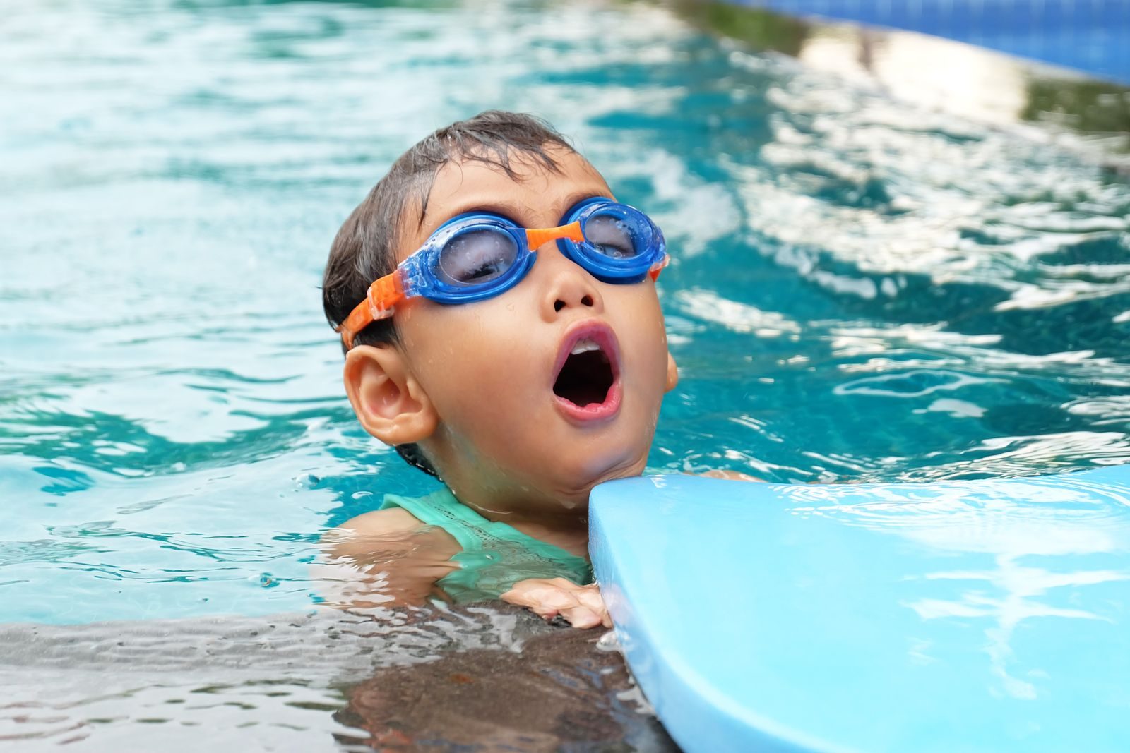 Un enfant avec des lunettes de natation dans une piscine