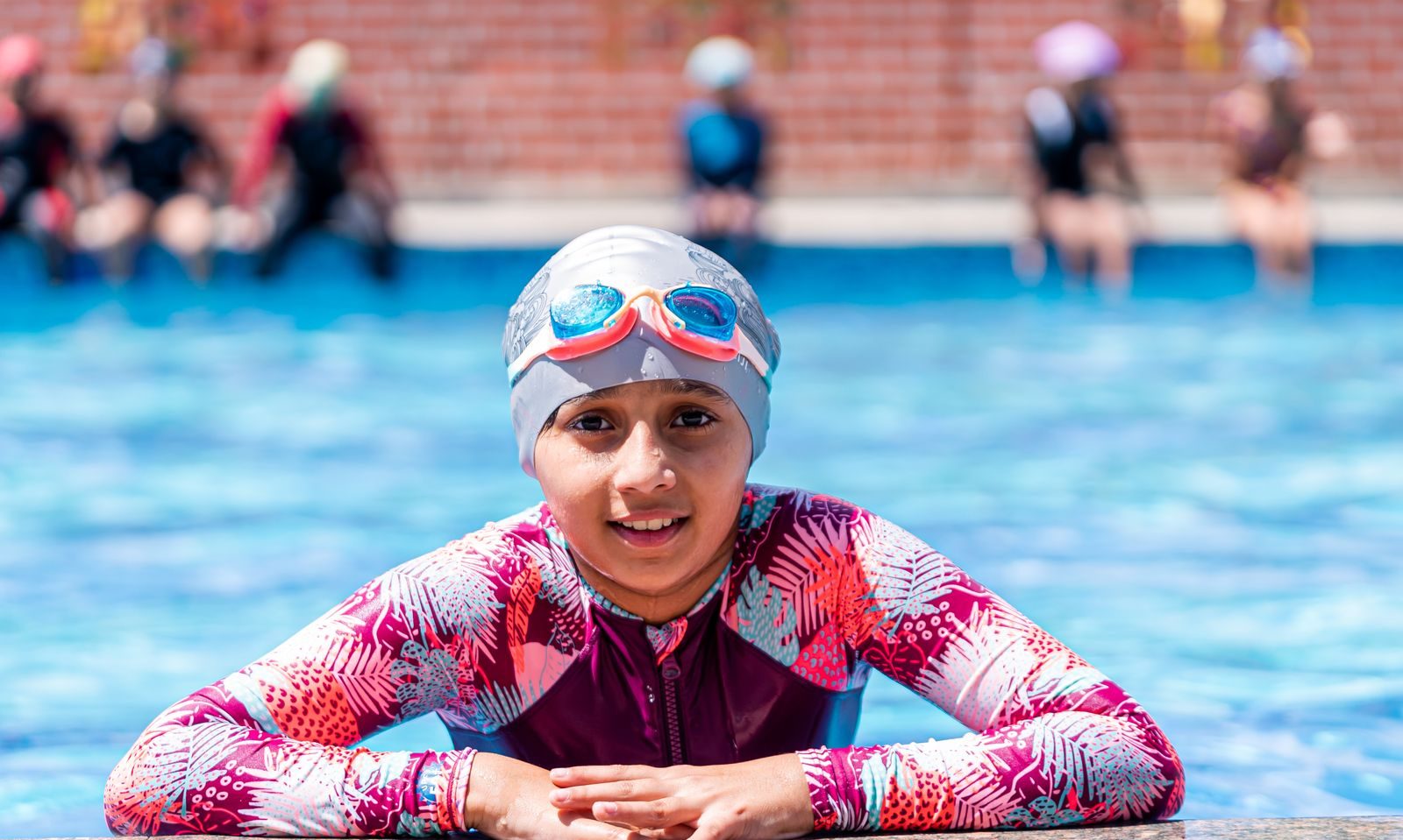 Enfant apprenant a nager dans une piscine exterieure