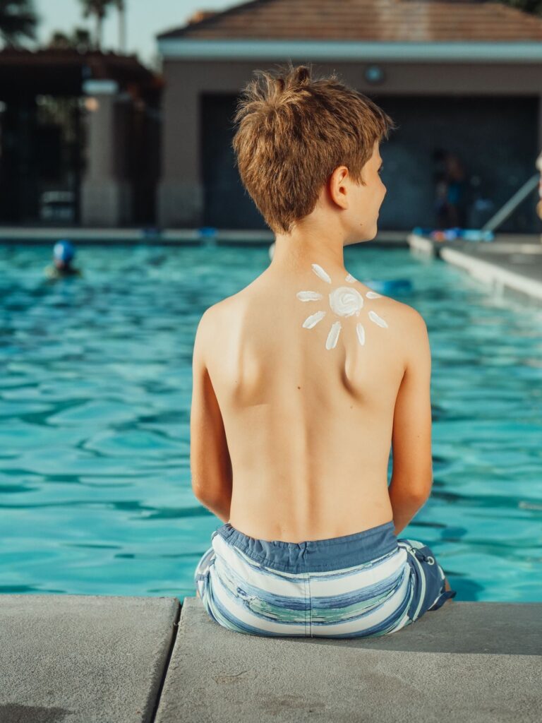 Enfant assis au bord d une piscine en ete