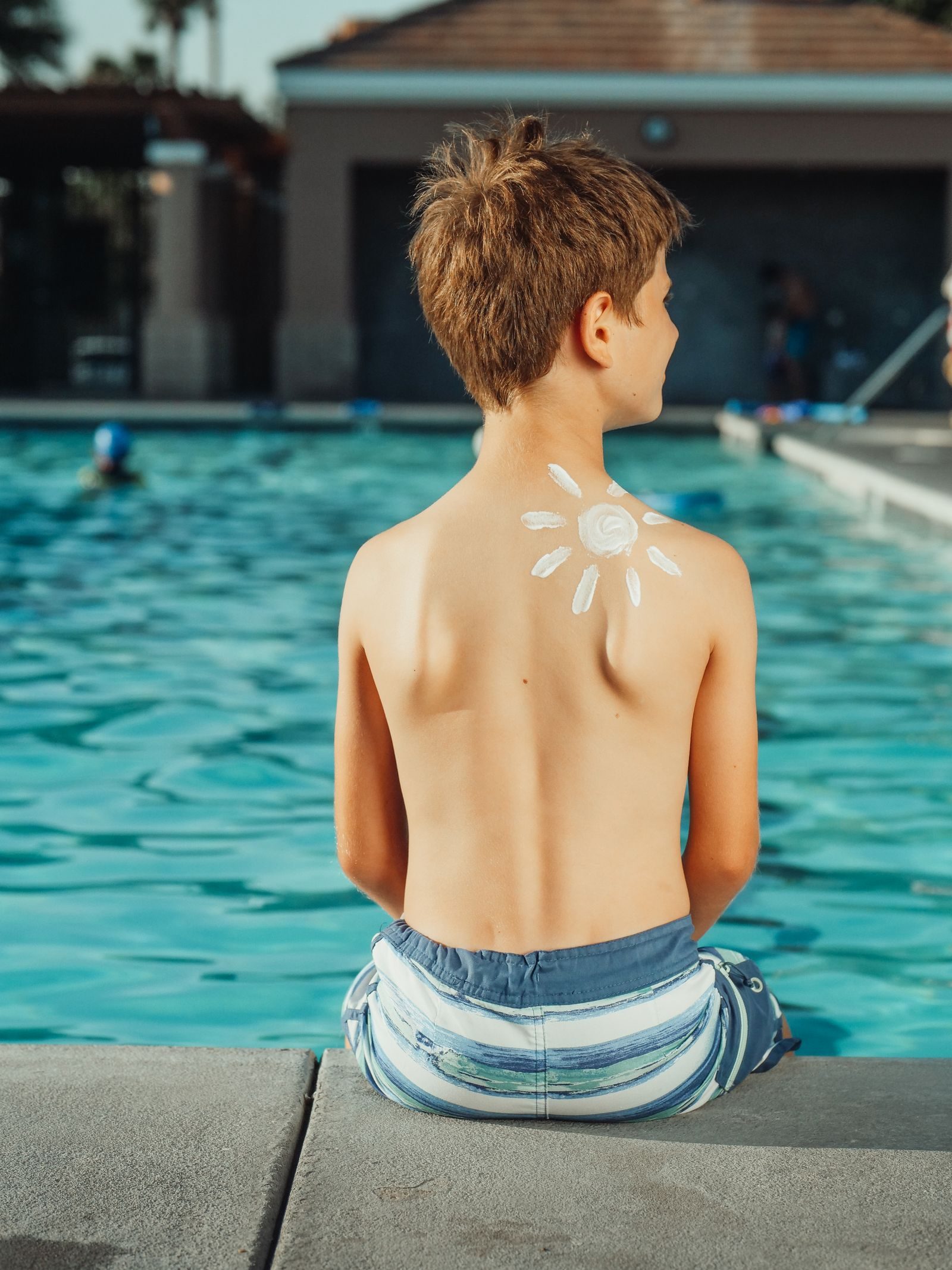 Enfant assis au bord d une piscine en ete