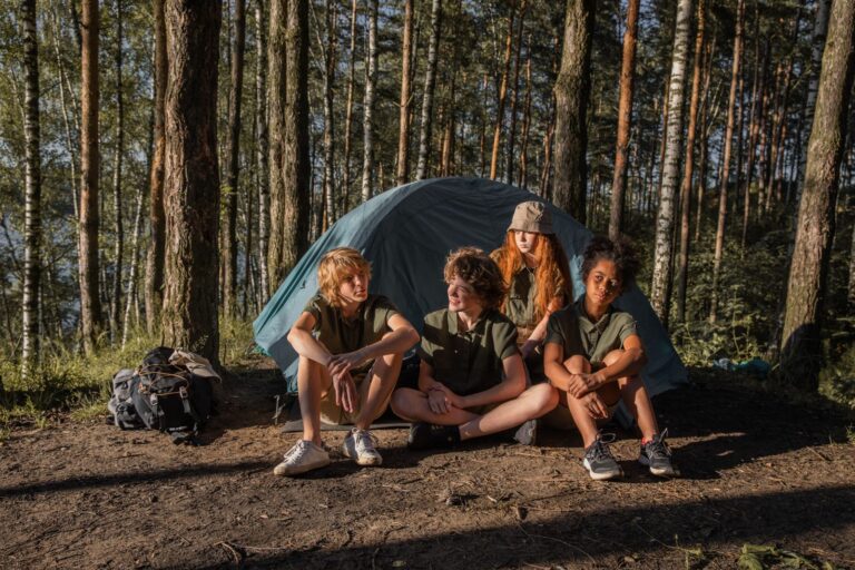 Enfants installes pres d une tente en foret pendant une colonie de vacances