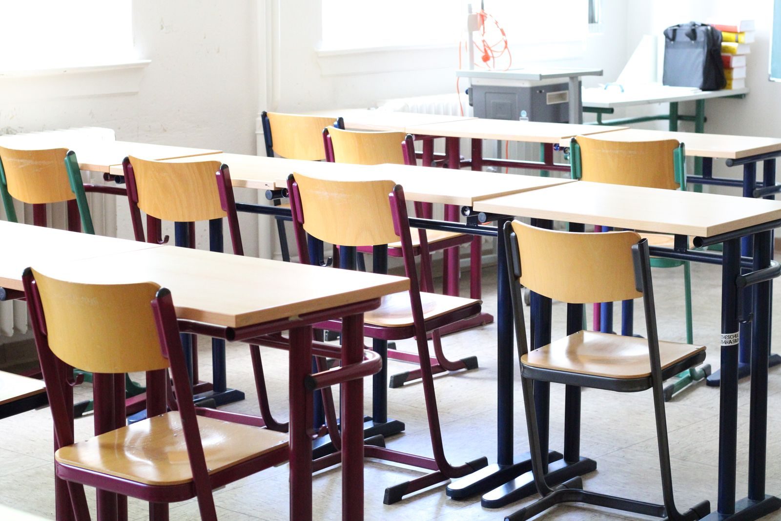 Salle de classe claire avec tables et chaises en bois prête pour la rentrée
