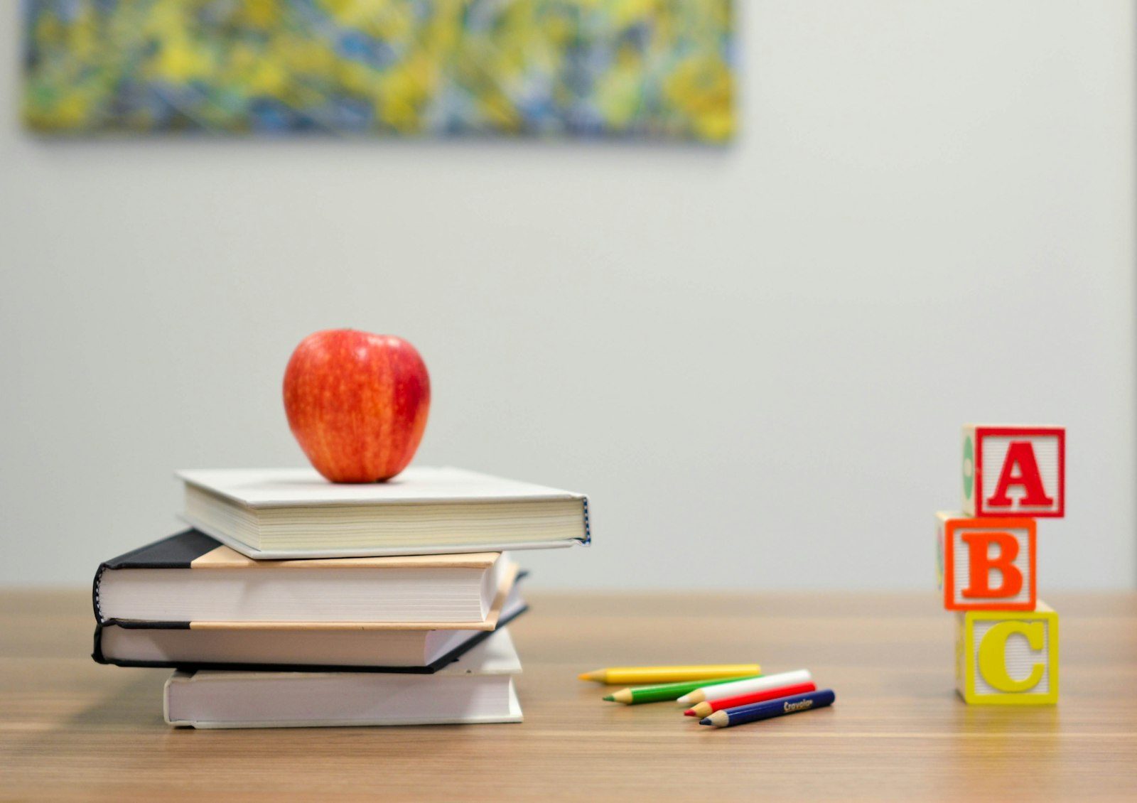 Livres, pomme et crayons de couleur sur un bureau, illustration de la rentree scolaire