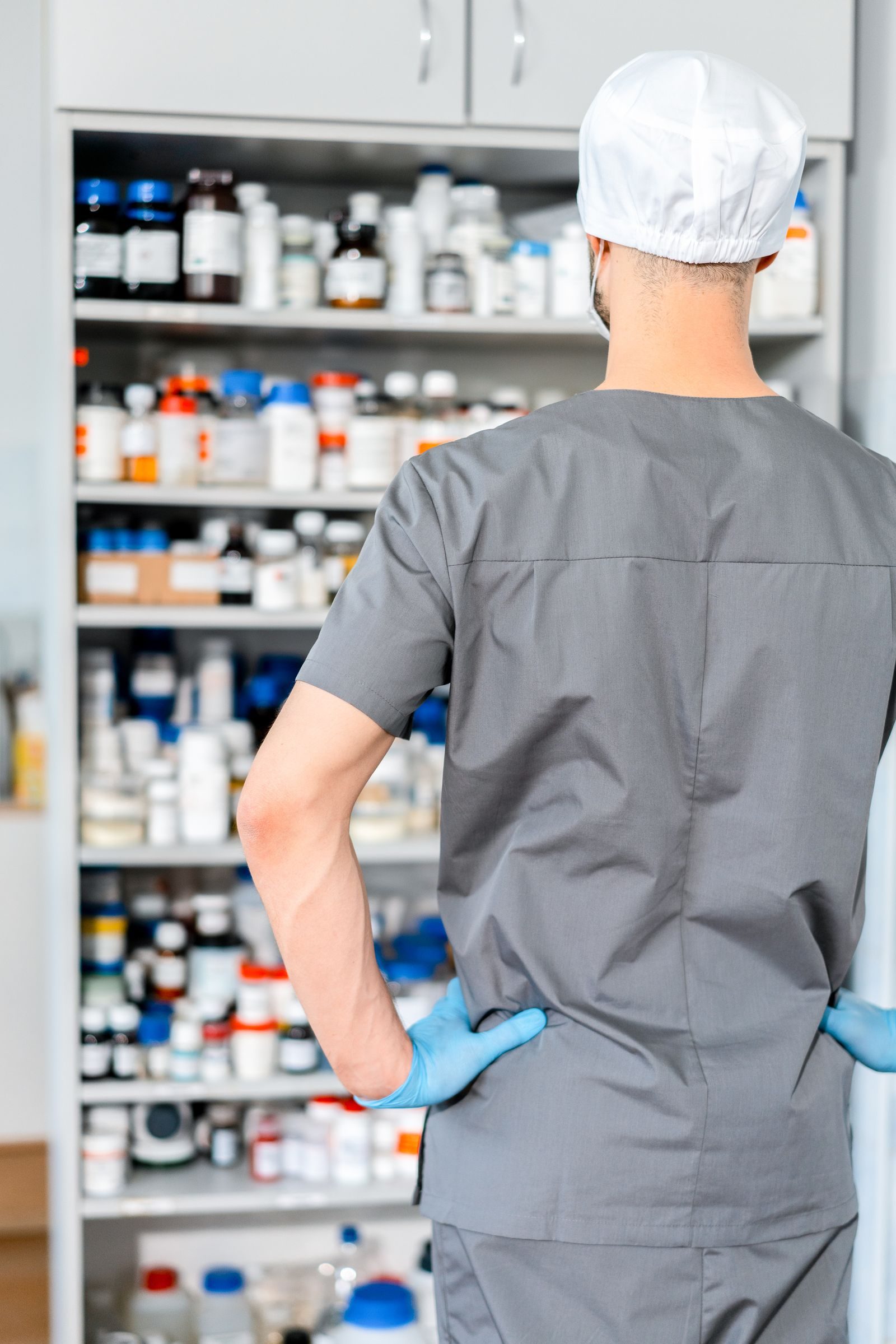 Pharmacien devant une armoire de medicaments en officine