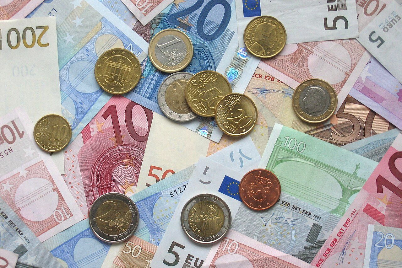 Pièces et billets en euros disposés sur une surface, illustration de l'épargne des ménages