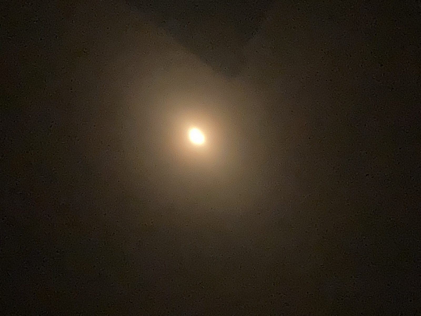 Le Soleil partiellement éclipsé observé à travers le filtre de lunettes d’éclipse certifiées.