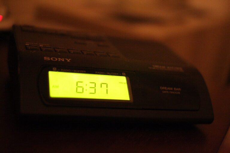 Radio-réveil numérique affichant 6 h 37 du matin, posé sur une table de nuit.