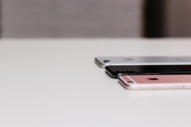 Trois smartphones posés côte à côte, illustrant le téléphone portable des élèves visé par la règle scolaire.