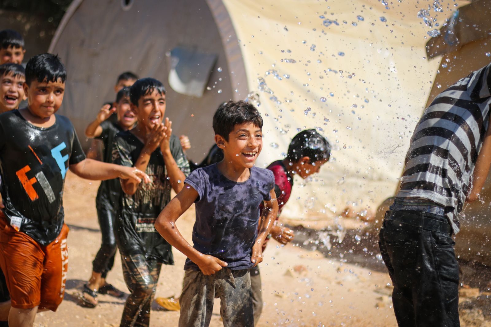 Des enfants se rafraichissent en jouant avec de l eau pendant l ete