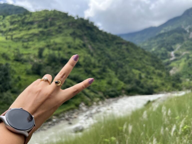 Une montre connectee a ecran rond portee au poignet, en exterieur.
