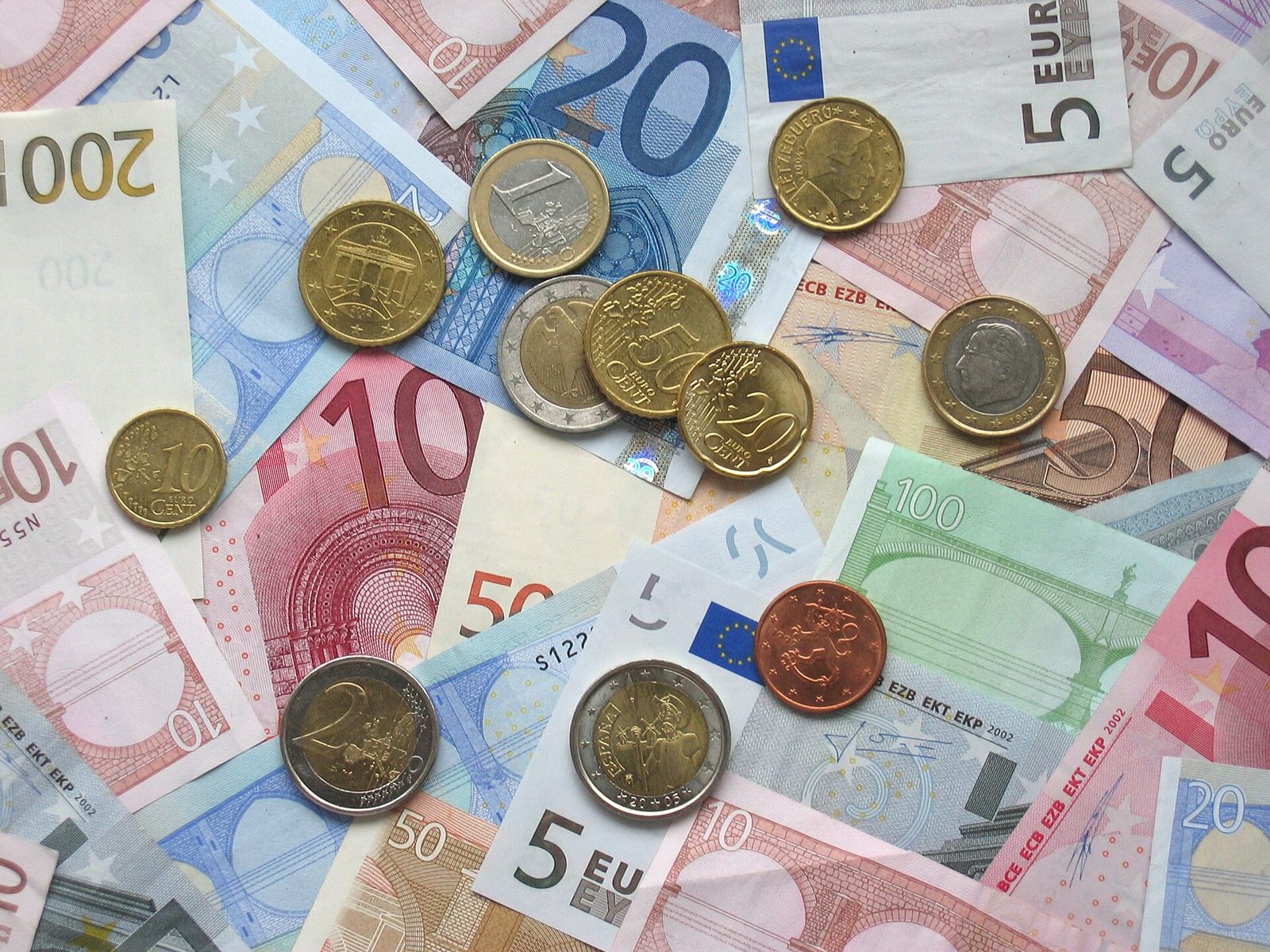Pièces et billets en euros posés sur une table, illustrant le budget et les aides au logement des familles.