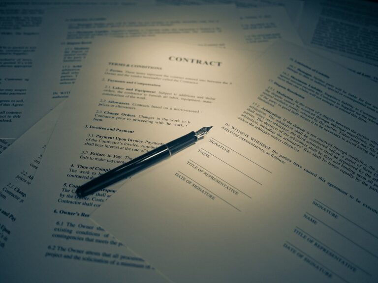 Un document de type contrat, avec des lignes de signature, sur lequel est posé un stylo plume.