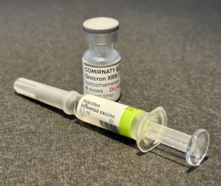 Un flacon de vaccin contre la Covid-19 (Comirnaty) et une seringue préremplie de vaccin contre la grippe.