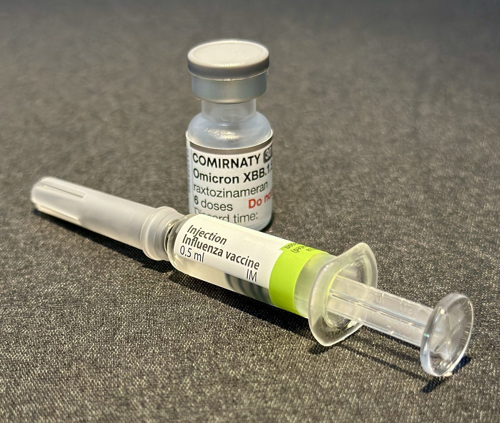 Un flacon de vaccin contre la Covid-19 (Comirnaty) et une seringue préremplie de vaccin contre la grippe.