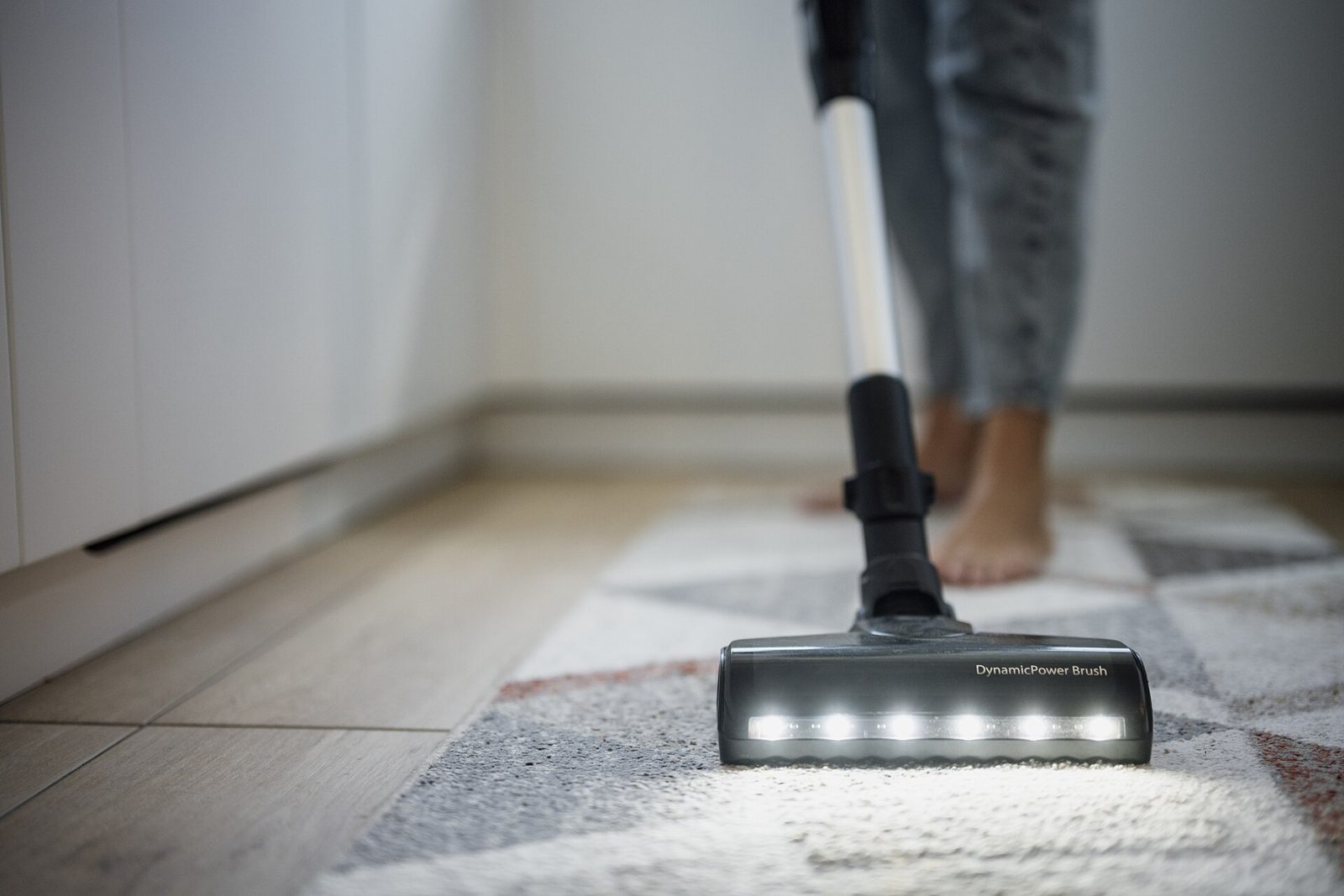 Aspirateur passe sur un tapis dans un interieur de maison, illustrant l aide aux taches du quotidien a domicile