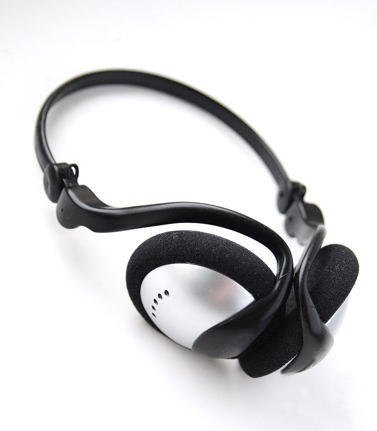 Un casque audio supra-auriculaire noir et argent pose sur un fond blanc