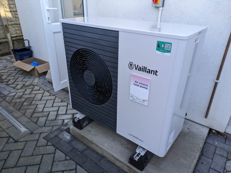 Unite exterieure d'une pompe a chaleur air/eau Vaillant aroTHERM plus installee contre le mur d'une maison individuelle.